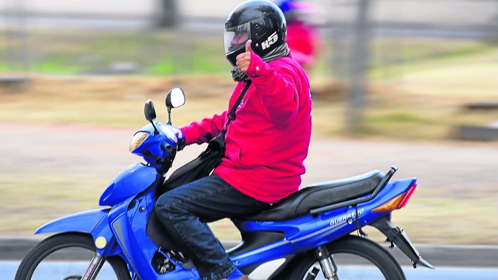 Persona con casco circulando en moto